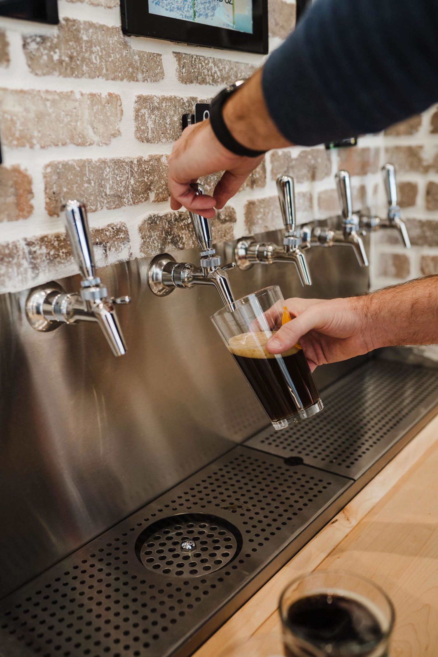 Pouring beer from the PourMyBeer wall at Pizza Artista in Greenville